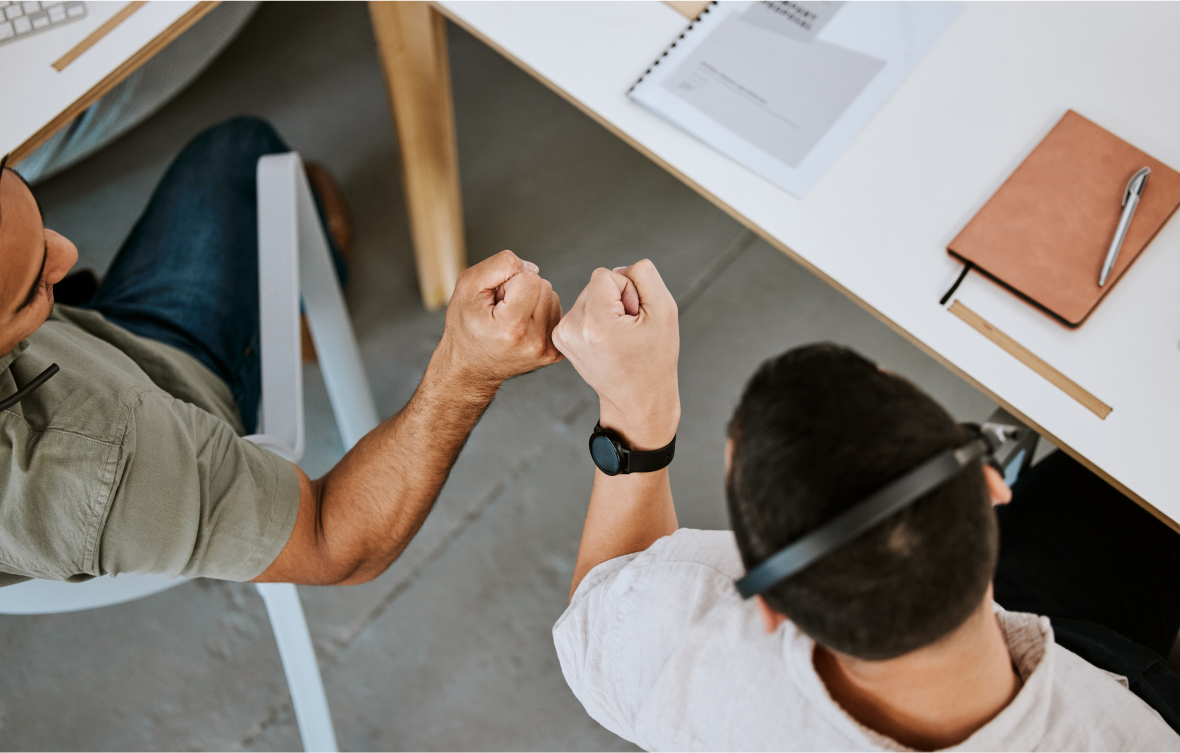 Two employees fist bumping.