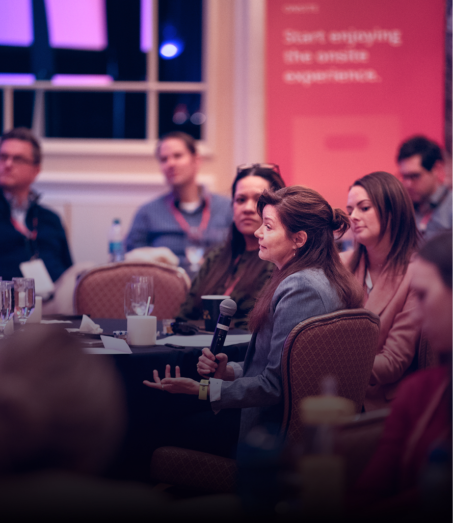 Event attendee asking a question with microphone during panel discussion