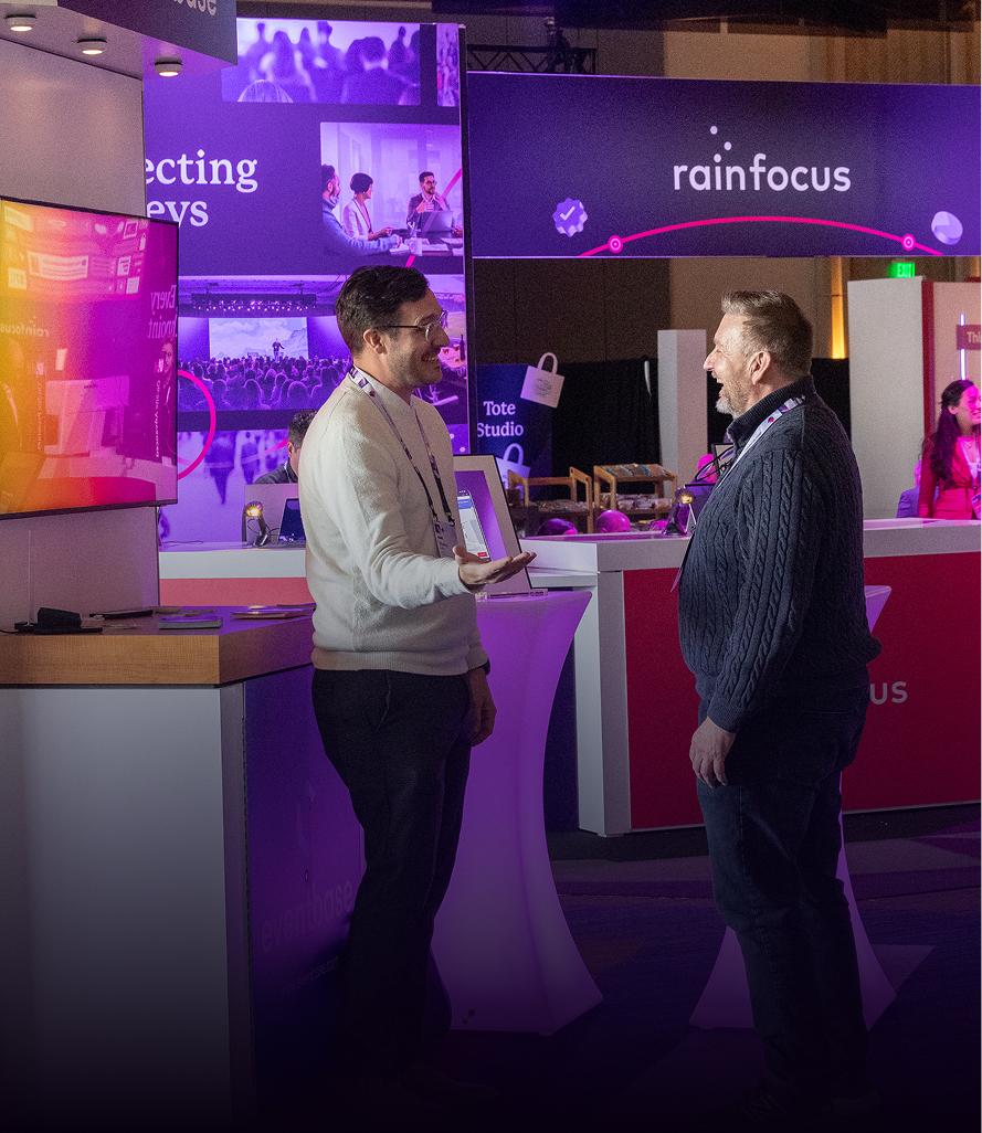 Two professionals networking at RainFocus exhibition booth